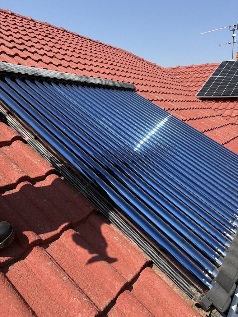 Tube collector for hot water on a tiled roof.