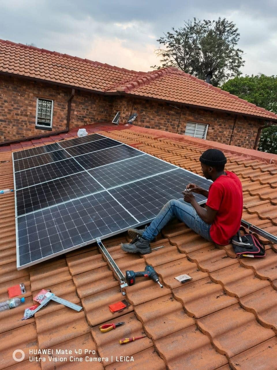 Clamping panels down on a tiled roof.