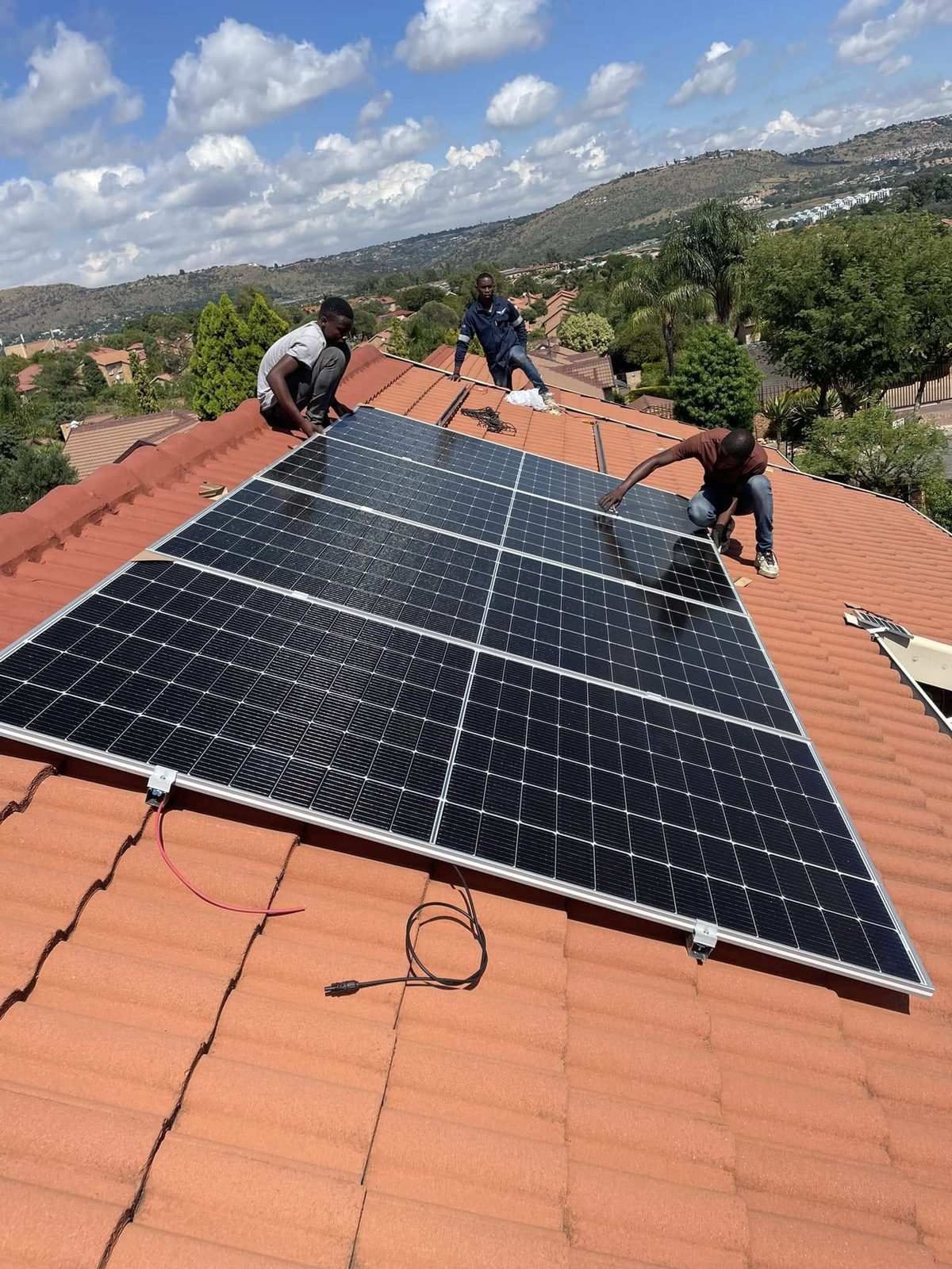 The team installing solar panels on a tiled roof