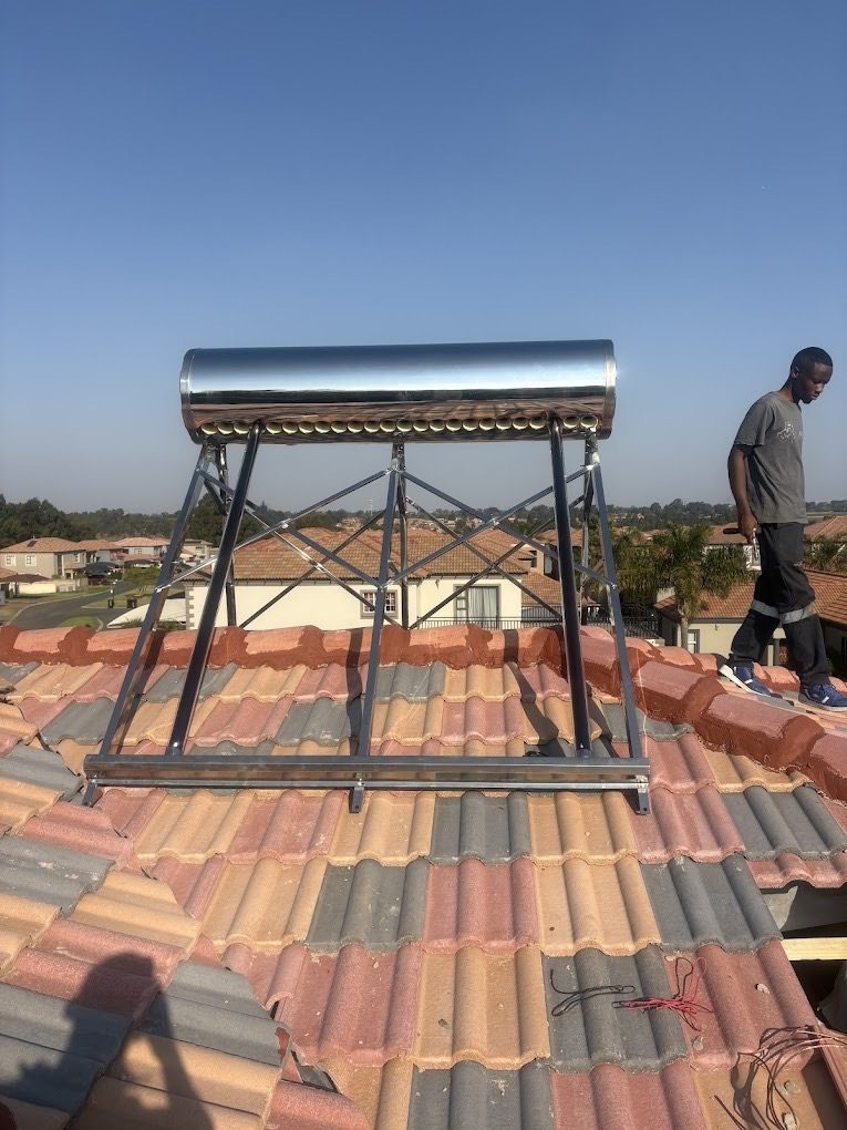 A solar geyser being installed on a tiled roof