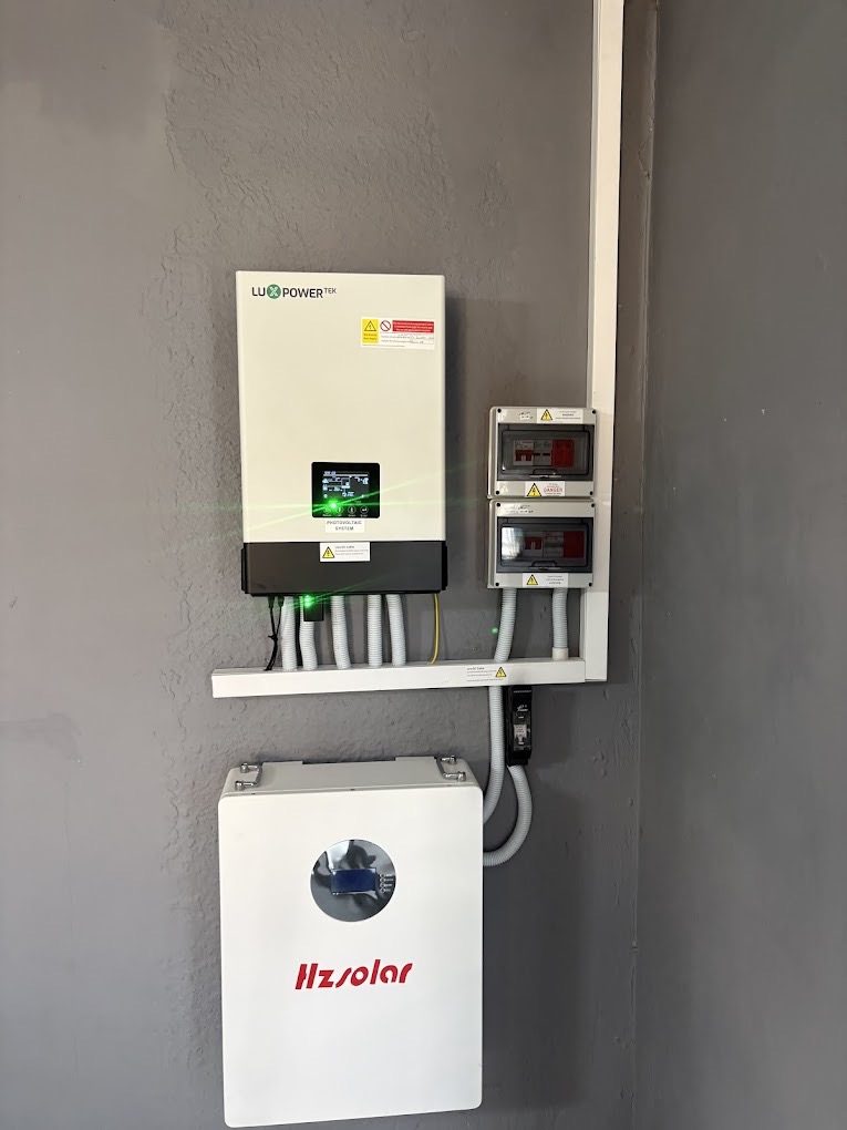 Hybrid inverter and battery on a clean interior wall.